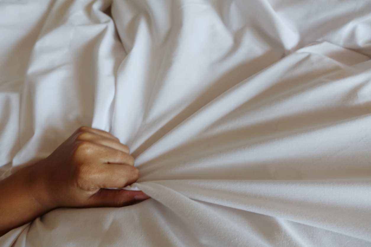 Mano de mujer agarrando la sábana