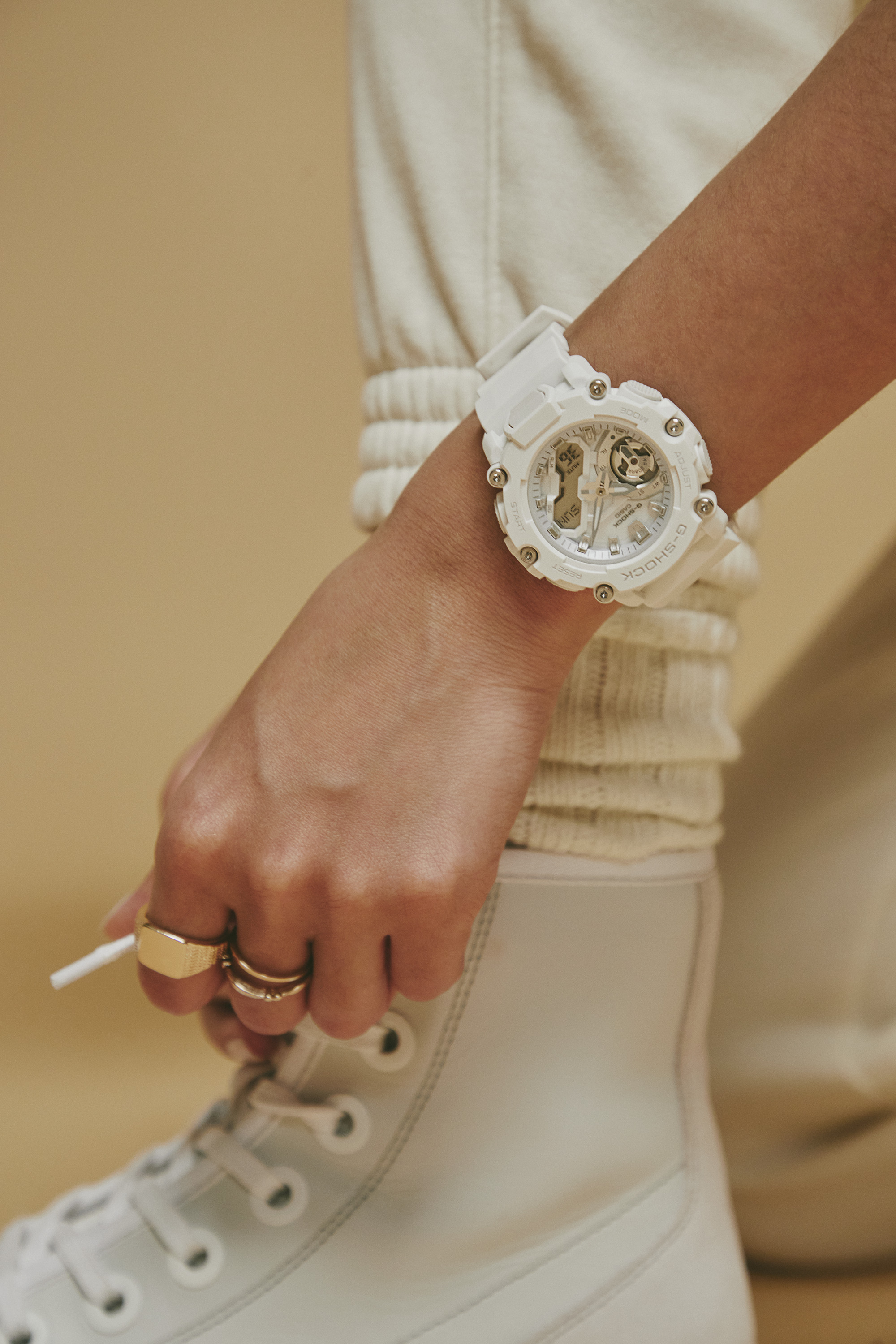 Reloj en la muñeca femenina combinado con un conjunto blanco